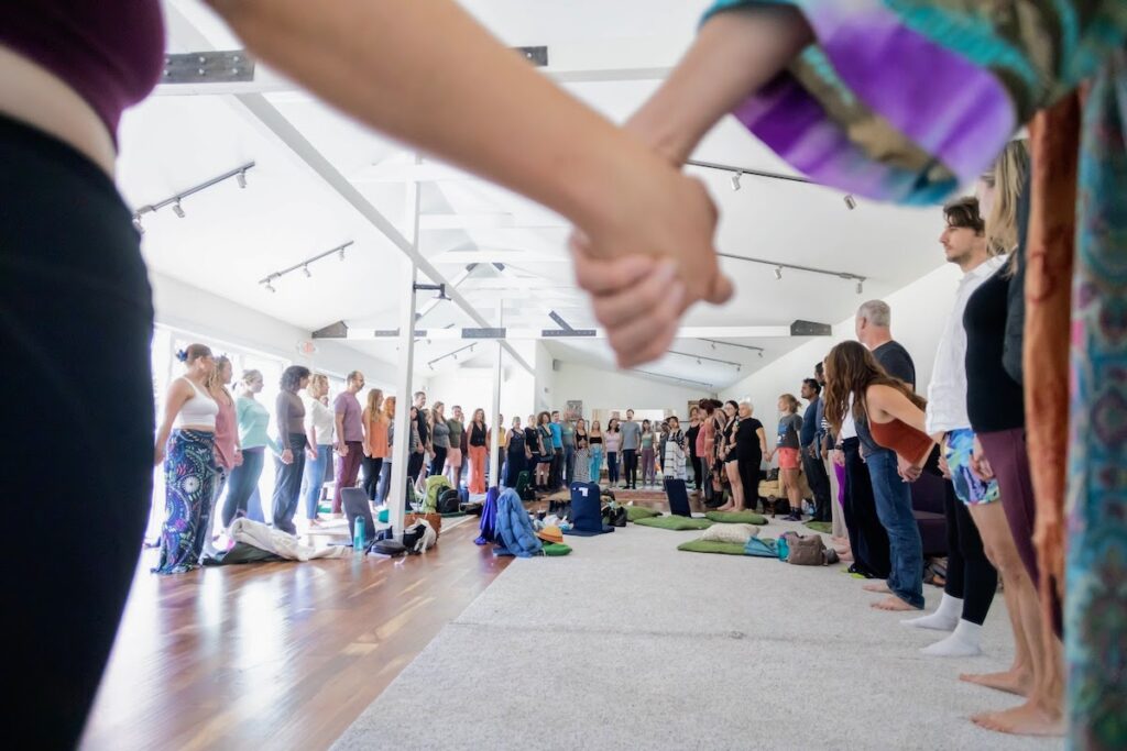 Participants holding hands in a circle at the Somatica Immersion Retreat