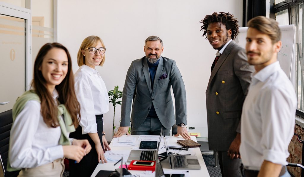 5 people in a business meeting looking at the camera, showcasing how important body language is