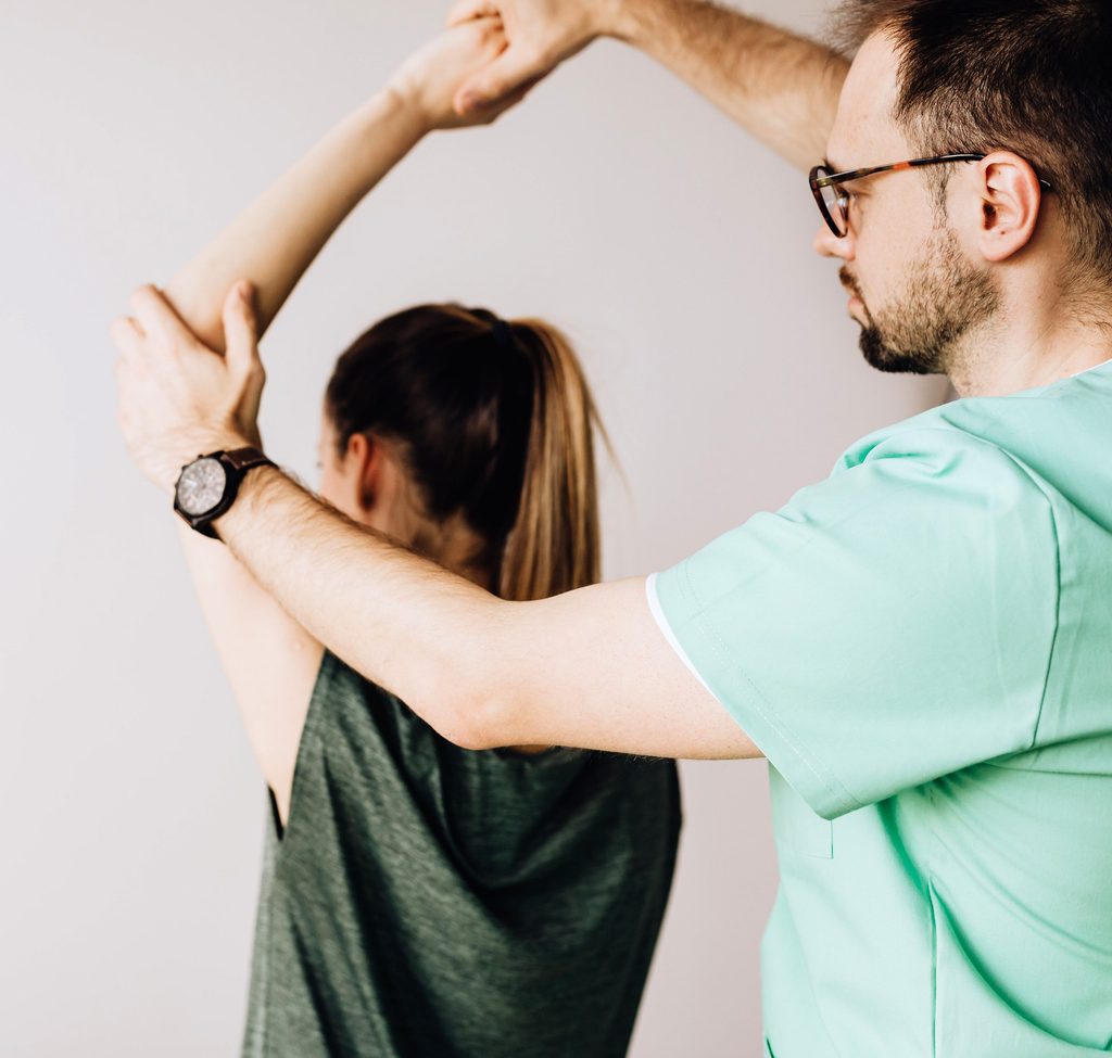 Physical therapist working with a client, demonstrating that this is a job AI can't replace
