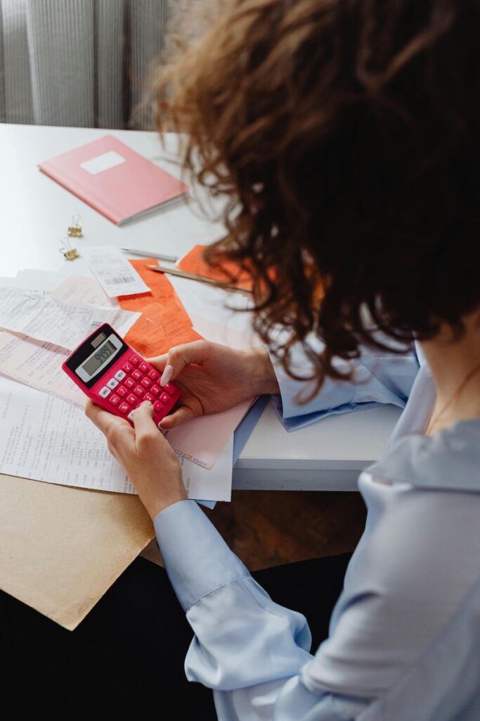 Woman with a calculator, figuring out the financial benefits of the Somatica training