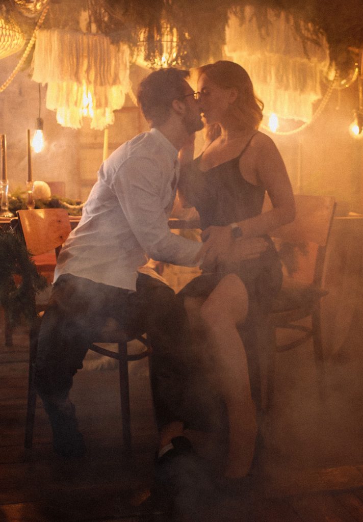 Beautiful couple sitting on chairs, kissing, and showing what positive power dynamics in relationships look like.