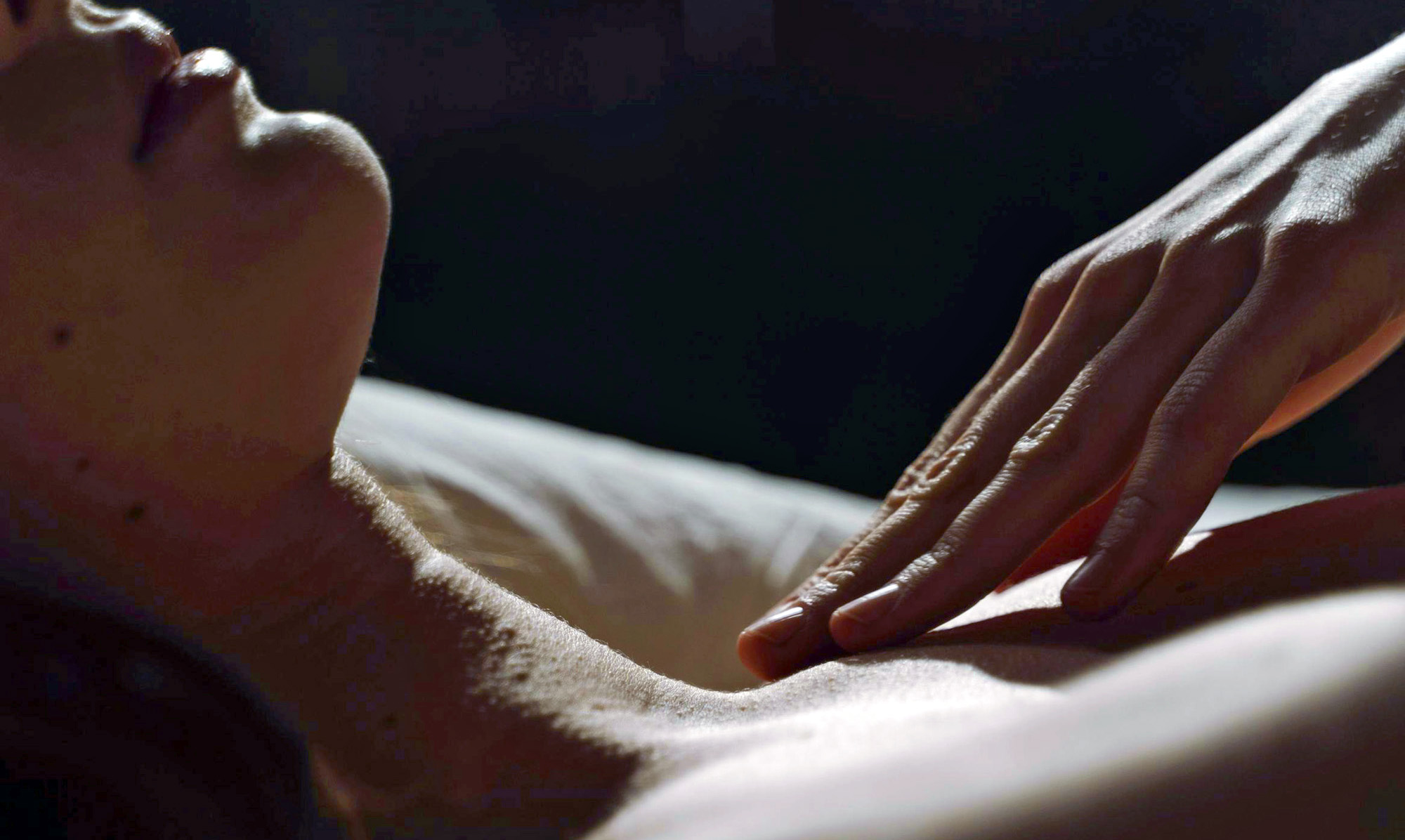 close-up of a person receiving a relaxing massage, hand on upper arm and chest