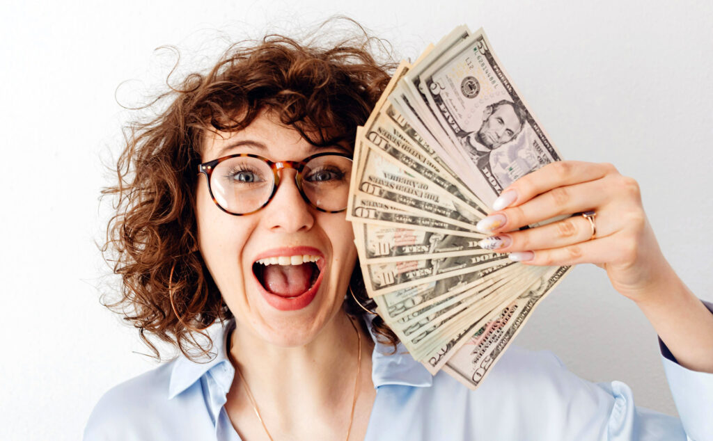 Sex coach holding a fan of dollar bills as her salary