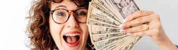 Sex coach holding a fan of dollar bills as her salary